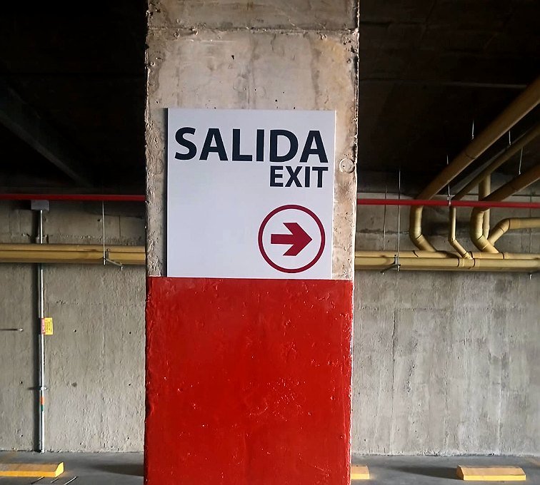 Señalización de salida de emergencia en sótano de parqueaderos